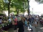 Multitud caminando entre los puestos del mercado en un día soleado