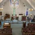 Vista interior de la nave principal con altar y vitral