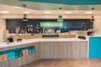 Interior moderno de la cafetería con mostrador y zona de preparación