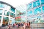 Vista exterior del centro comercial Manchester Arndale con fachada de cristal y gente caminando