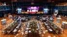Sala principal configurada para evento con mesas redondas y decoración