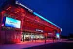 Fachada iluminada en rojo del Boeing Center at Tech Port durante la noche