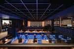 Interior del Haus Glasgow con barra iluminada en azul y zona de eventos