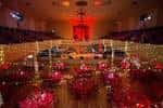 Sala decorada para evento con mesas redondas y luces cálidas