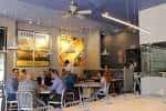 Ambiente interior del local con comensales y arte en las paredes