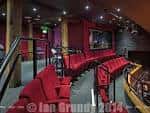 Interior del auditorio con butacas rojas y escenario