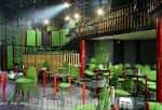 Espacio de eventos con decoración verde y zona elevada