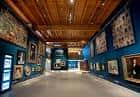 Interior de la galería con paredes azules y obras expuestas