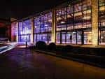 Fachada exterior iluminada del Boiler Shop por la noche