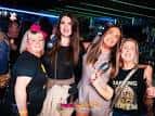 Grupo de personas sonriendo y celebrando dentro del club nocturno