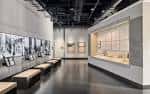 Interior de la sala de exposiciones con paneles históricos y vitrinas iluminadas