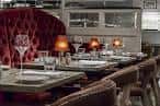 Interior elegante del Atlantic Bar & Brasserie con mesas dispuestas y sillas rojas