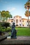 Estatua en primer plano con fachada del museo al fondo