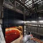 Interior del auditorio del Citizens Theatre mostrando las butacas rojas y la estructura industrial del techo