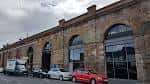 Fachada exterior del edificio Tramway con arcos de ladrillo y ventanas grandes