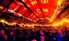 Interior del auditorio principal con iluminación cálida y público asistiendo a un evento