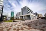Plaza pavimentada frente al complejo académico de GCU bajo un cielo parcialmente nublado
