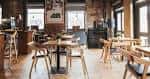 Interior del bar con mesas de madera y ambiente acogedor
