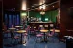 Interior del bar con mesas y sillas dispuestas para eventos