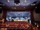 Interior del auditorio con butacas rojas y cortinas decorativas