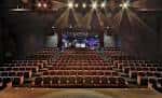Aula magna con butacas marrones y sistema de iluminación profesional