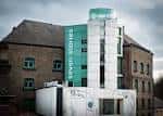 Fachada exterior de Seven Stories con su distintiva torre verde y blanca