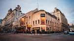 Fachada completa del Palace Theatre en Manchester al atardecer, mostrando su arquitectura histórica