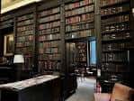 Interior de la biblioteca con estanterías llenas de libros y ambiente histórico
