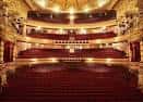 Interior del auditorio principal con butacas rojas y balcones ornamentados