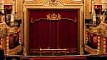Escenario con cortina roja y decoración dorada en el interior del teatro