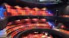Interior del auditorio con butacas rojas y escenario iluminado