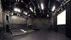 Interior del auditorio vacío con escenario y sistema de iluminación profesional