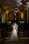 Pareja en boda dentro del museo, con dinosaurio al fondo