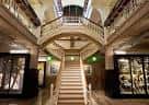 Gran escalera interior del museo con balcones y vitrinas
