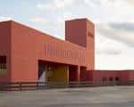 Vista exterior del edificio de la biblioteca con fachada roja y diseño arquitectónico moderno