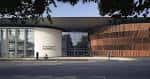 Fachada exterior moderna del Royal Welsh College con paredes de madera y cristal