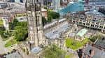 Vista aérea de la Catedral de Manchester mostrando su arquitectura gótica y el entorno urbano circundante