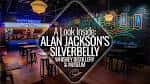Interior del Silverbelly Whiskey Distillery con barra y ambiente nocturno