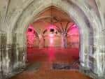Cripta de la iglesia iluminada con luces rojas, ideal para eventos nocturnos