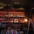 Interior del bar mostrando estanterías con botellas y ambiente acogedor