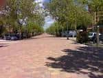 Vista panorámica de la Avenida de Colmenar Viejo en Tres Cantos con árboles y vehículos estacionados