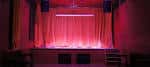 Escenario del local Gullivers con cortinas rojas e iluminación ambiental