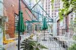 Terraza exterior del YES Manchester con mesas y sombrillas verdes