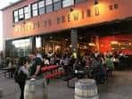 Vista exterior de Station 26 Brewing Co. con clientes en el patio