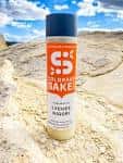Botella de Lychee Nigori Sake de Colorado Sake Co. en un entorno natural al aire libre