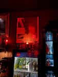 Interior del O'Death Cafe con iluminación roja y estantería de bebidas