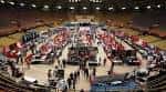 Interior del coliseo durante un evento con stands y público en las gradas