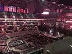 Interior del arena con escenario montado y gradas iluminadas en tono morado