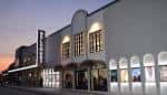 Fachada exterior del Belcourt Theatre al atardecer con iluminación cálida