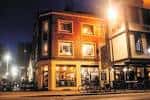 Fachada nocturna del edificio del Exchange en Bristol, mostrando su arquitectura urbana e iluminación cálida